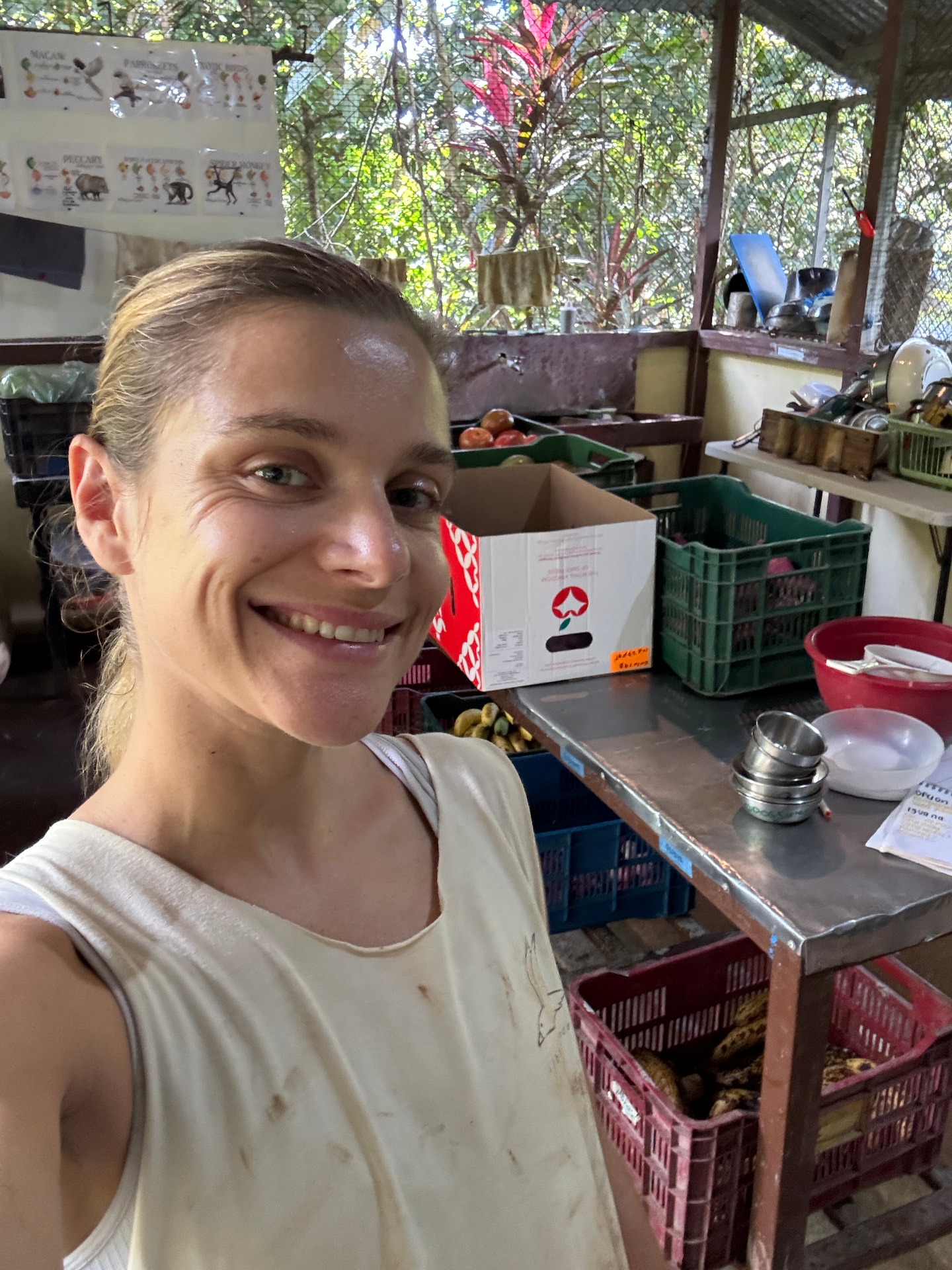 Clé smiling in the sanctuary kitchen surrounded by crates of fruit